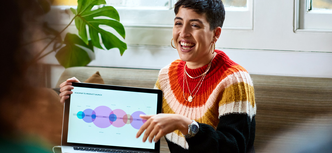 A smiling business woman displaying a road map chart from her laptop