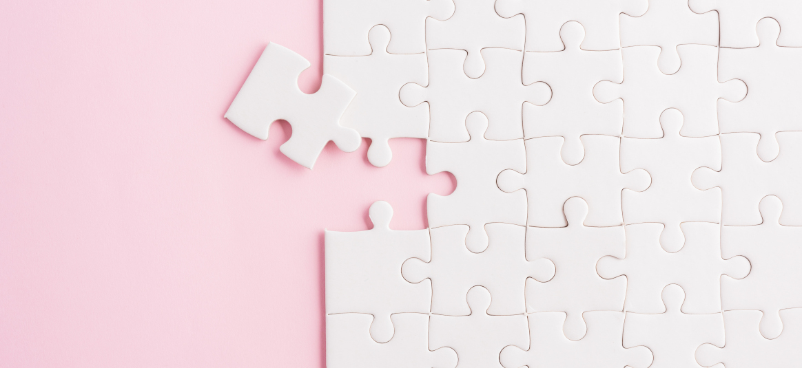 picture of all white jigsaw on a pink background